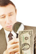 Man looks through a magnifying glass on the dollar banknote