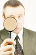 Man looks through a magnifying glass