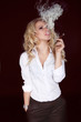 Photo: Sexy Woman with Cigar Exhaling Smoke on Dark Background Sexy Woman with Cigar Exhaling Smoke on Dark Background