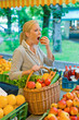Frau am Obstmarkt mit Einkaufskorb