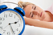 Schlaflos mit Uhr in der Nacht.