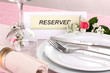 Table setting with reserved card in restaurant