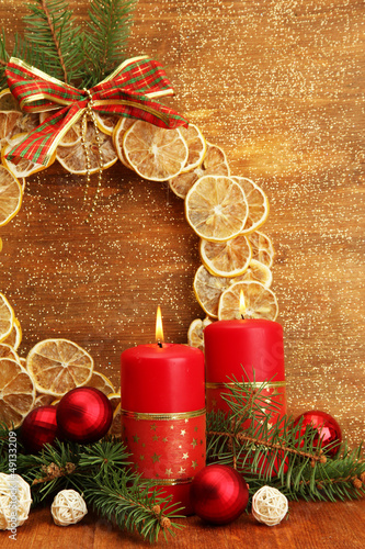 Photo: Two candles and christmas decorations, on golden background Two candles and christmas decorations, on golden background