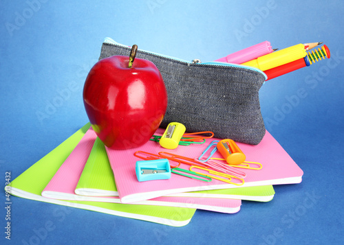 Photo: pencil box with school equipment on blue background pencil box with school equipment on blue background
