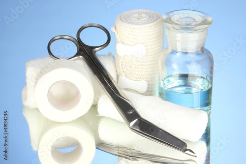 Photo: First aid kit for bandaging on blue background First aid kit for bandaging on blue background