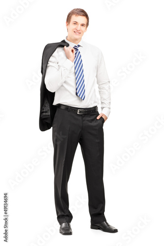 Photo: Full length portrait of a young businessman posing with a coat o Full length portrait of a young businessman posing with a coat o