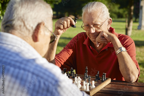 Photo: Active retired people, two senior men playing chess at park Active retired people, two senior men playing chess at park