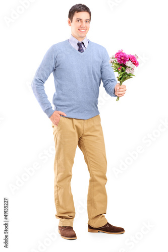 Photo: Full length portrait of a young romantic man holding a bouquet o Full length portrait of a young romantic man holding a bouquet o