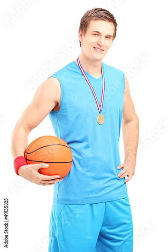 Photo: Winner basketball player posing with a golden medal Winner basketball player posing with a golden medal