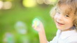 Video: Happy child blowing soap bubbles in spring park. Slow motion Happy child blowing soap bubbles in spring park. Slow motion