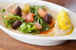 Photo: Bowl of hummus garnished with salad and pepper Bowl of hummus garnished with salad and pepper