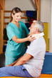 Alter Mann mit Halskrause bei Physiotherapie