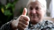Seniorin mit Daumen