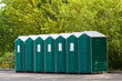 Green plastic toilet booths in park