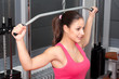 Beautiful young woman exercising with weights in the gym