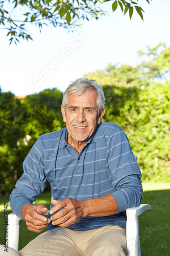 Photo: Senior sitzt im Sommer im Garten Senior sitzt im Sommer im Garten