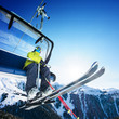 Skier siting on ski-lift - lift at sunny day and mountain