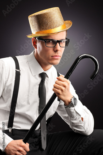 Photo: Portrait of a stylish man with hat holding a cane Portrait of a stylish man with hat holding a cane
