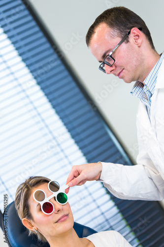 Photo: Optometry concept - pretty young woman having her eyes examined Optometry concept - pretty young woman having her eyes examined