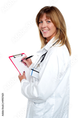 Photo: Beautiful smiling physician writing prescription Beautiful smiling physician writing prescription