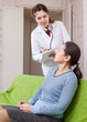 woman tells the doctor the symptoms of malaise