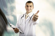 Smiling medical doctor with stethoscope on the hospitals backgro