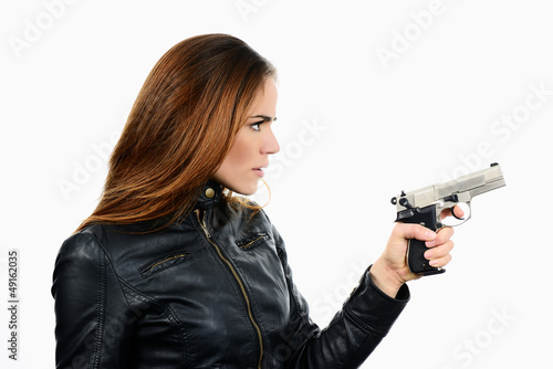 Photo: Young beautiful woman holding a gun on white background Young beautiful woman holding a gun on white background