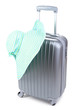 Silver suitcase with woman's hat  isolated on white