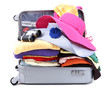 Open silver suitcase with clothing isolated on white