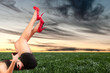 girl lying on meadow at sunset with a glass of wine in hand