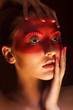Fashion Art Concept. Beauty Woman Face with Red Painted Mask