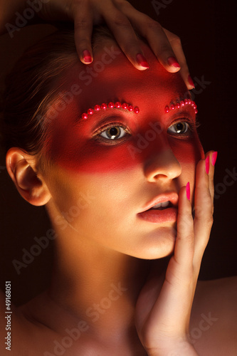 Photo: Fashion Art Concept. Beauty Woman Face with Red Painted Mask Fashion Art Concept. Beauty Woman Face with Red Painted Mask
