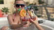 Girlfriends raising toast with drinks in hot tub, slow motion
