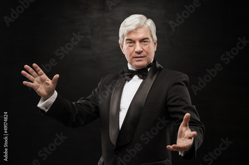 Photo: Portrait of professional hypnotist on black background Portrait of professional hypnotist on black background