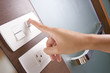 female hand turn on white electricity switch