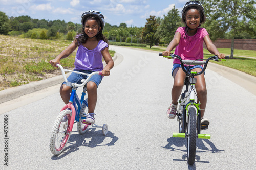 Photo: Happy African American Girls Riding Bikes Happy African American Girls Riding Bikes