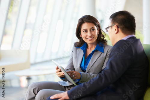 Photo: Business people With Digital Tablet Sitting In Modern Office Business people With Digital Tablet Sitting In Modern Office