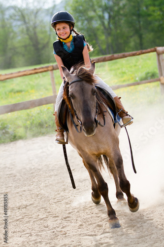 Photo: Horse riding - lovely girl is riding on a horse Horse riding - lovely girl is riding on a horse