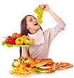 Woman choosing between fruit and hamburger.
