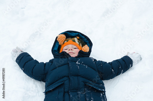 Photo: Little boy playing snow angels Little boy playing snow angels