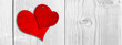 Conceptual two red old paper vintage hearts nailed on white wood