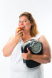 Obese woman with scale under arm and apple