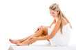 Woman applying cream on her legs