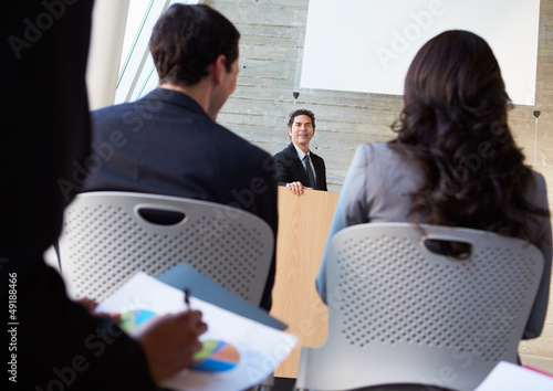 Photo: Businessman Delivering Presentation At Conference Businessman Delivering Presentation At Conference