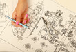Female architect working with blueprints at office desk