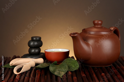 Photo: Chinese tea ceremony on bamboo table on brown background Chinese tea ceremony on bamboo table on brown background