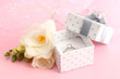 Beautiful box with wedding ring and flower on pink background