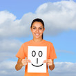 Foto: Girl holding a paper with a happy face painted Girl holding a paper with a happy face painted