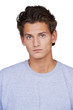 Serious young guy looking at you against a white background