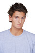 Serious young guy looking at you against a white background